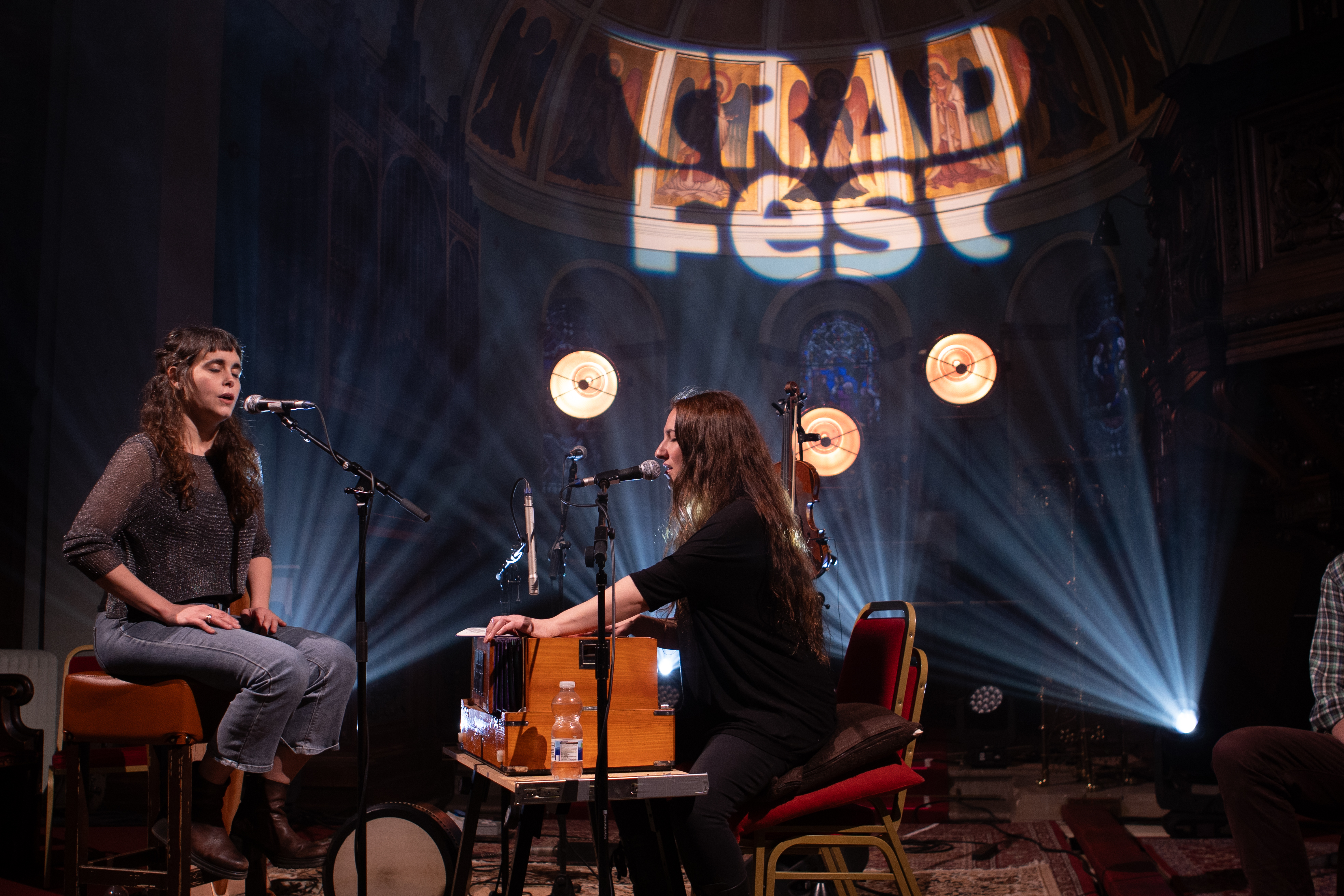 Trad Fest logoet oplyst på et loft med musikere foran
