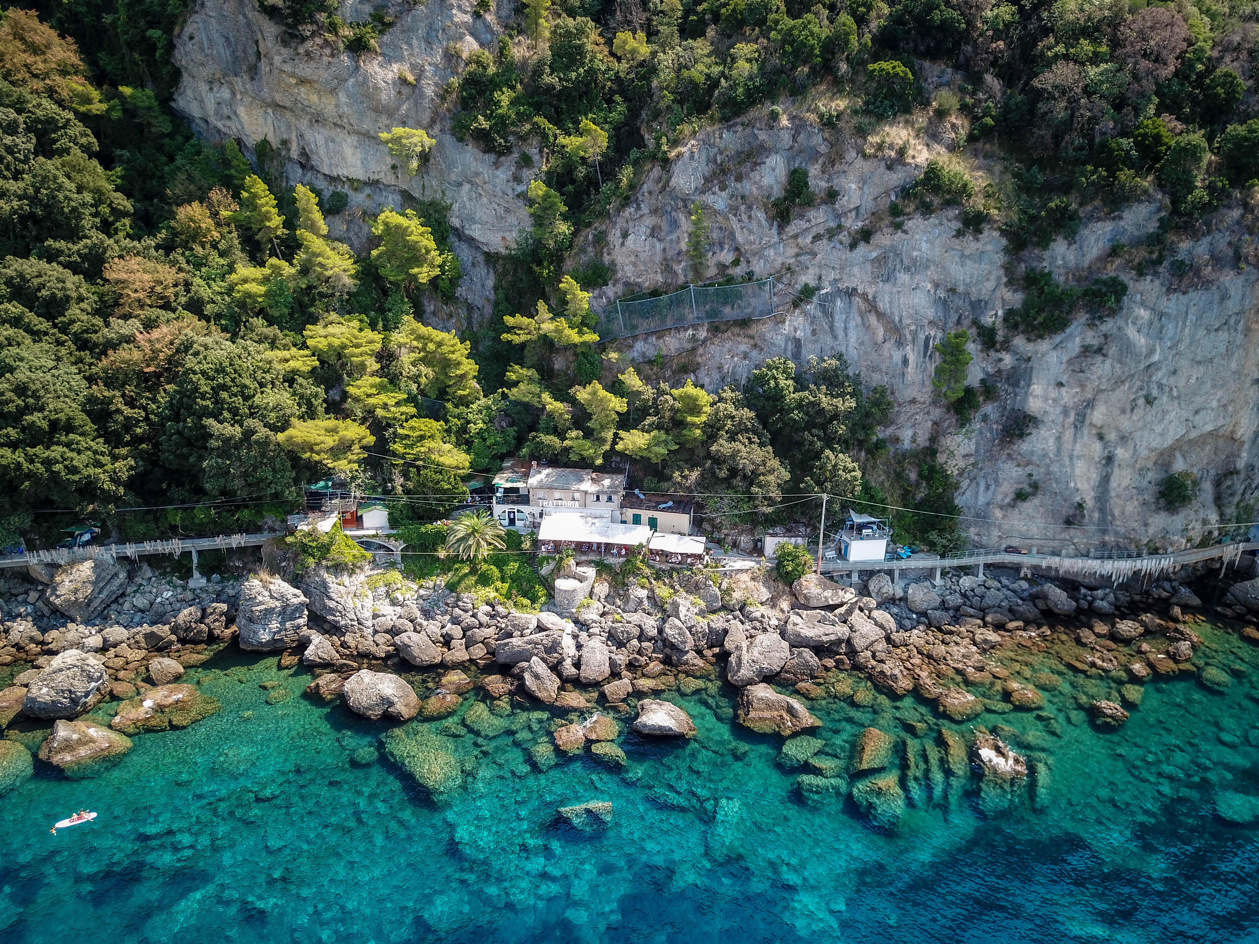 Luftfoto af Punta Chiappa kystlinje, Portofino, Italien med klipper og turkis hav.