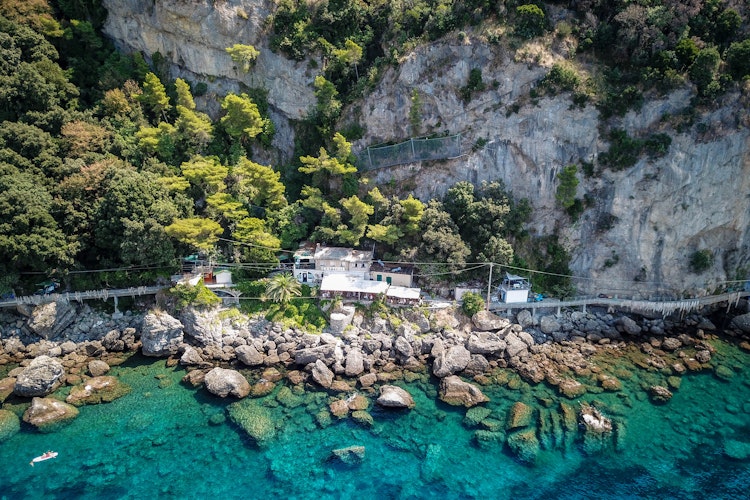 Luftfoto af Punta Chiappa kystlinje, Portofino, Italien med klipper og turkis hav.