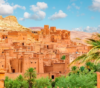 Den historiske lerby Ait Ben Haddou i Marokko, UNESCO verdensarv omgivet af palmetræer og ørkenlandskab ved foden af Atlasbjergene