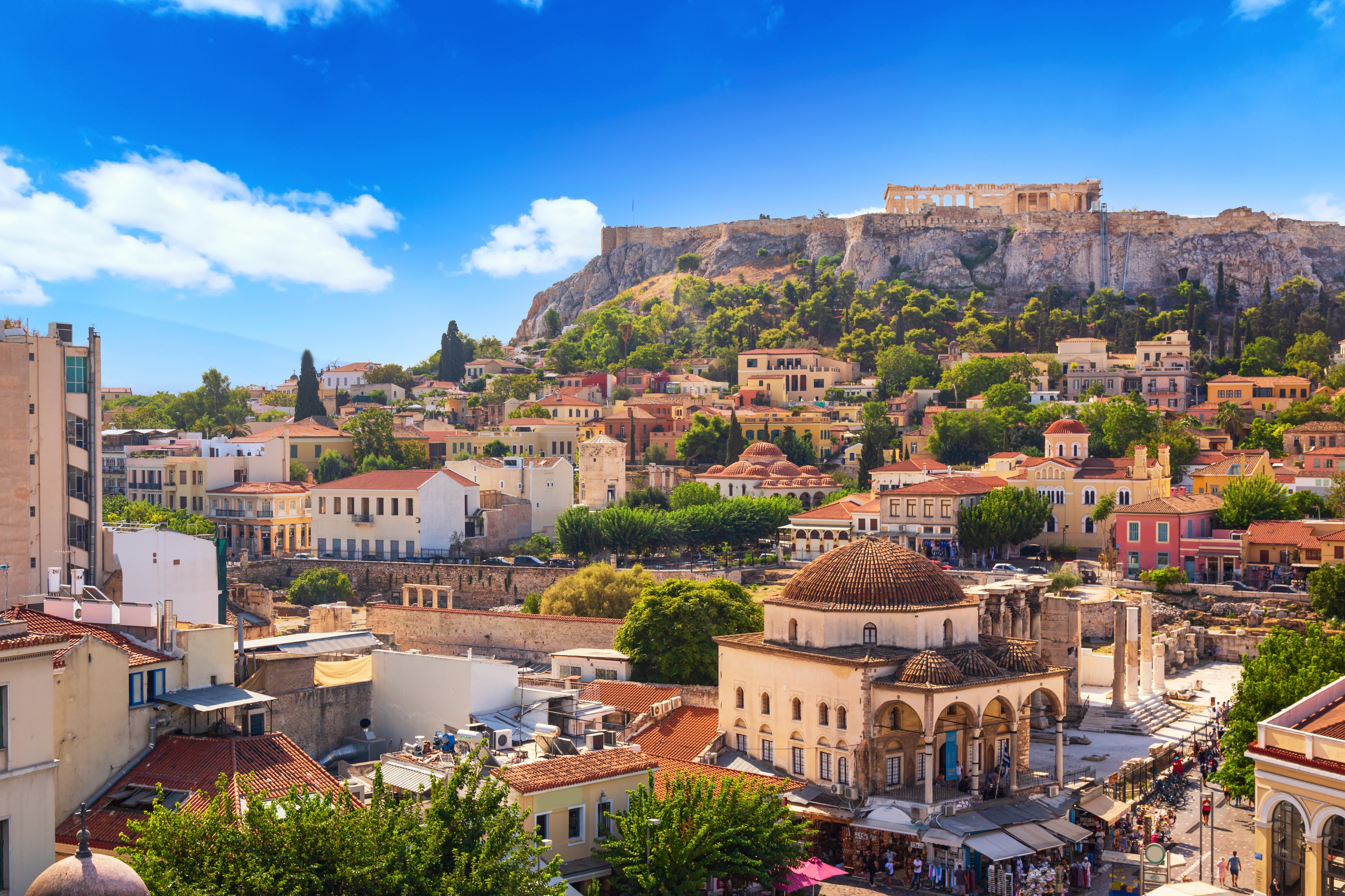 Panoramaudsigt over Athen med Akropolis på bakketoppen og de farverige bygninger i Monastiraki og Plaka-kvarteret badet i solskin