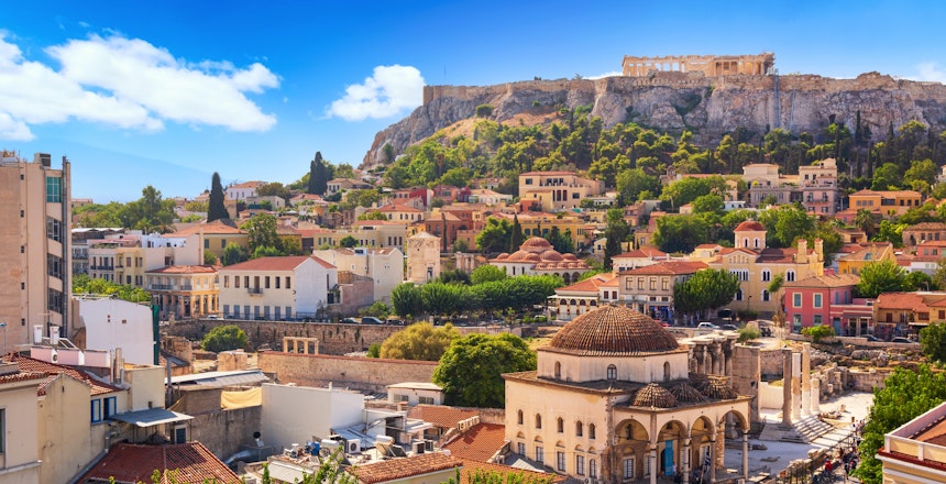 Panoramaudsigt over Athen med Akropolis på bakketoppen og de farverige bygninger i Monastiraki og Plaka-kvarteret badet i solskin