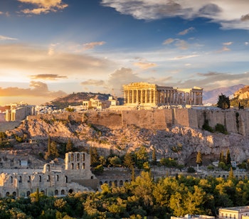 Akropolis i Athen med Parthenon-templet badet i gyldent solnedgangslys over den historiske græske hovedstad