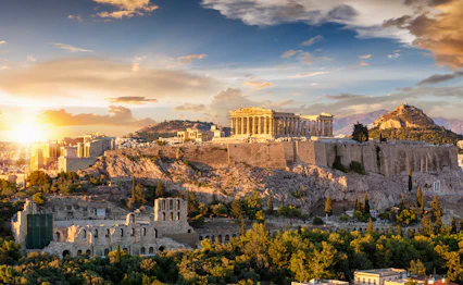 Akropolis i Athen med Parthenon-templet badet i gyldent solnedgangslys over den historiske græske hovedstad