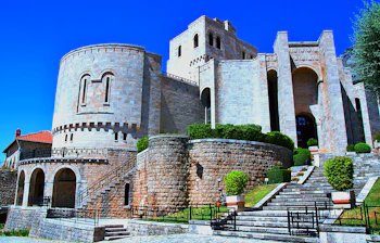 Middelalderlig stenborg med cylindriske taarne og historiske mure under blaa himmel i Albanien