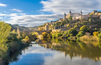 Den historiske Alcazar-fæstning i Toledo set fra Alcantara-broen over Tagus-floden i Castile-La Mancha, Spanien