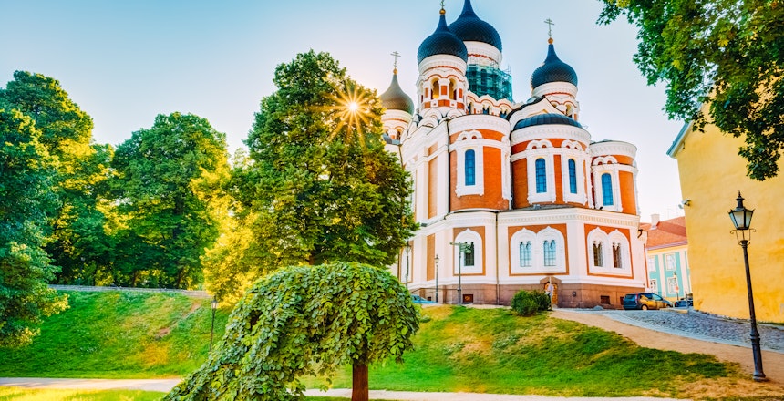 Alexander Nevsky-katedralen med blå kupler i Tallinns gamle bydel, Estland, fotograferet på en solrig sommerdag omgivet af grønne træer