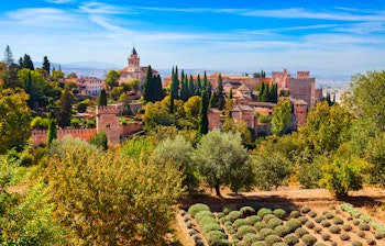 Panoramaudsigt over Alhambra-fæstningen med frodige haver og cyprestræer i Granada, Andalusien, Spanien