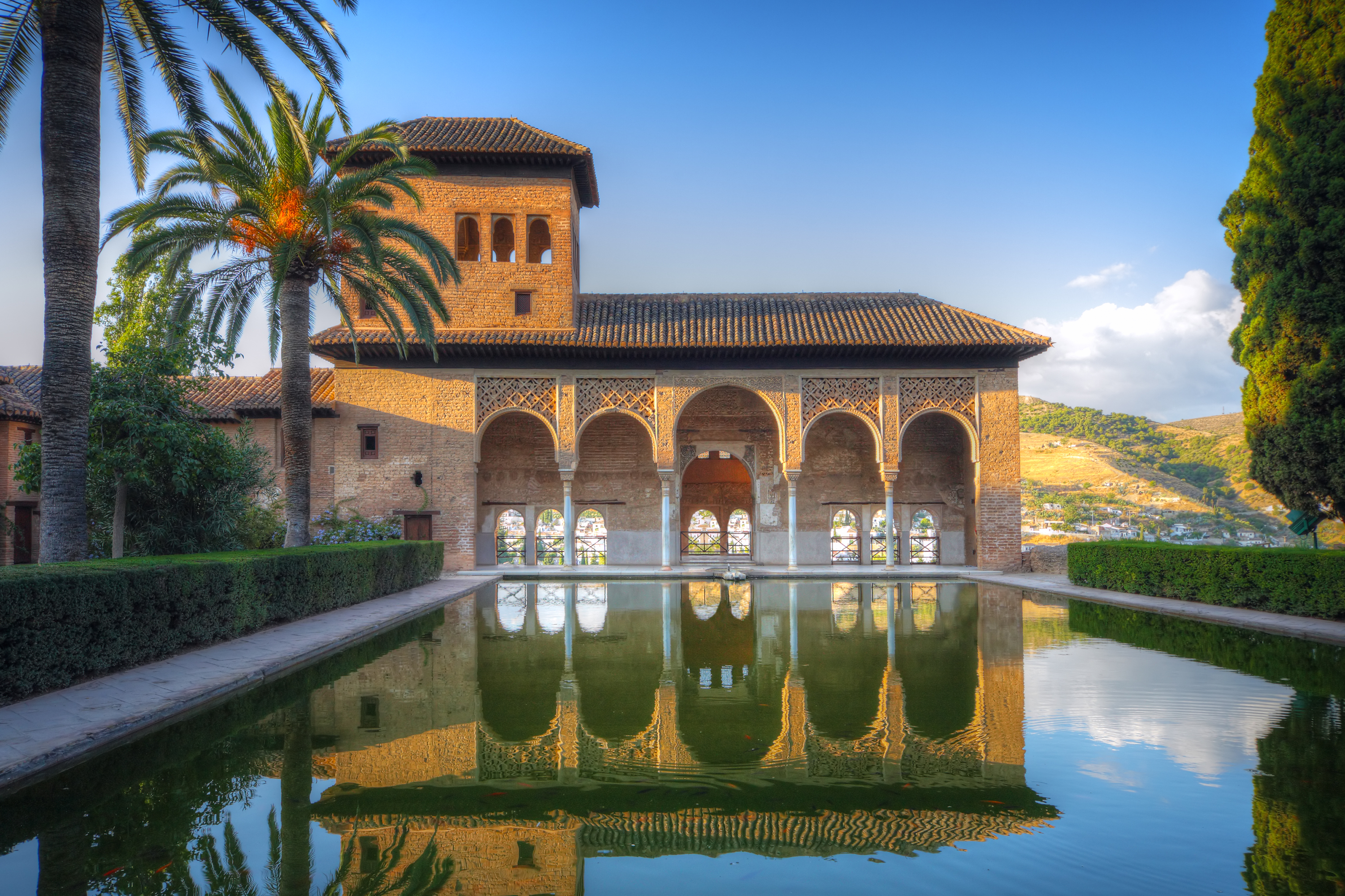 Fredfyldt gårdhave med spejlbassin i Alhambra-paladset, der viser den mauriske arkitektur i Granada, Spanien