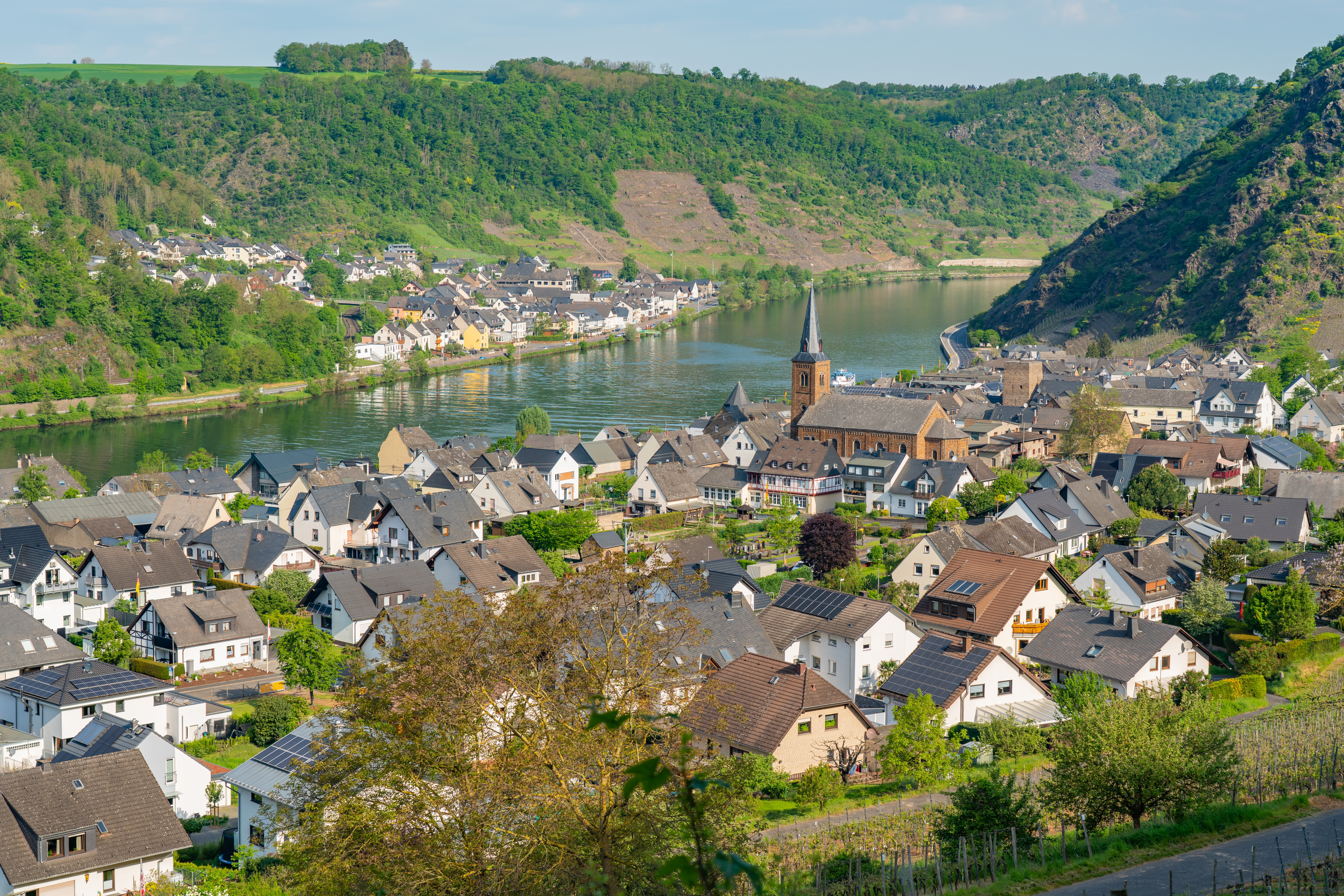 Luftudsigt over den charmerende by Alken ved Mosel-floden i Rhineland-Palatinate, Tyskland, omgivet af grønne bakker og vingårde om foråret
