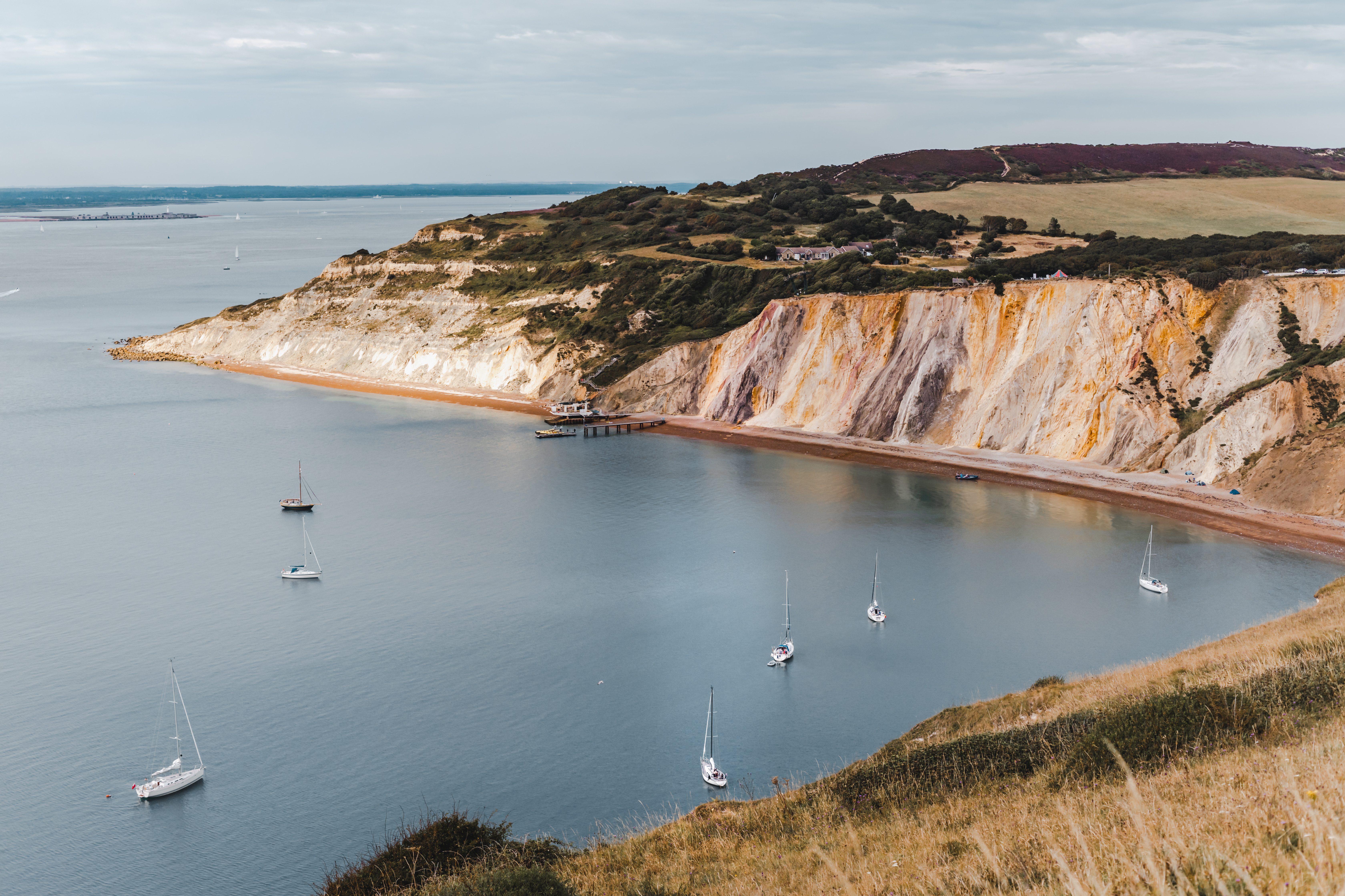 Alum Bay på Isle of Wight med sejlbåde og dramatiske kridtklipper ved den engelske kanal