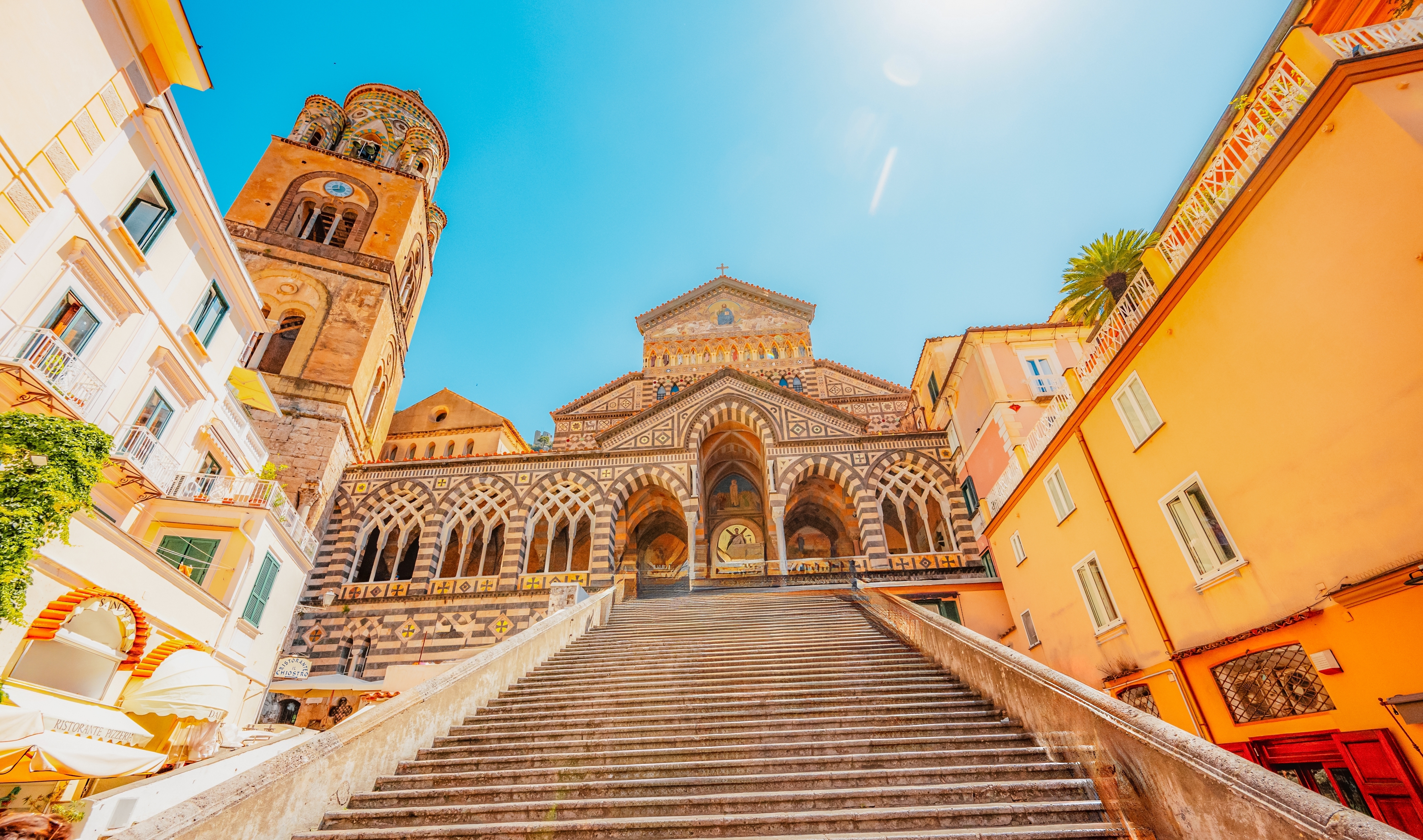 Det ikoniske klokketårn på Amalfi Domkirke med sin karakteristiske stribede facade - et historisk landemærke på Piazza del Duomo i hjertet af Amalfi by på den smukke italienske kyst