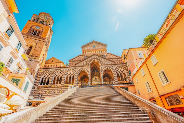 Det ikoniske klokketårn på Amalfi Domkirke med sin karakteristiske stribede facade - et historisk landemærke på Piazza del Duomo i hjertet af Amalfi by på den smukke italienske kyst