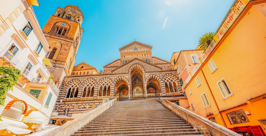 Det ikoniske klokketårn på Amalfi Domkirke med sin karakteristiske stribede facade - et historisk landemærke på Piazza del Duomo i hjertet af Amalfi by på den smukke italienske kyst