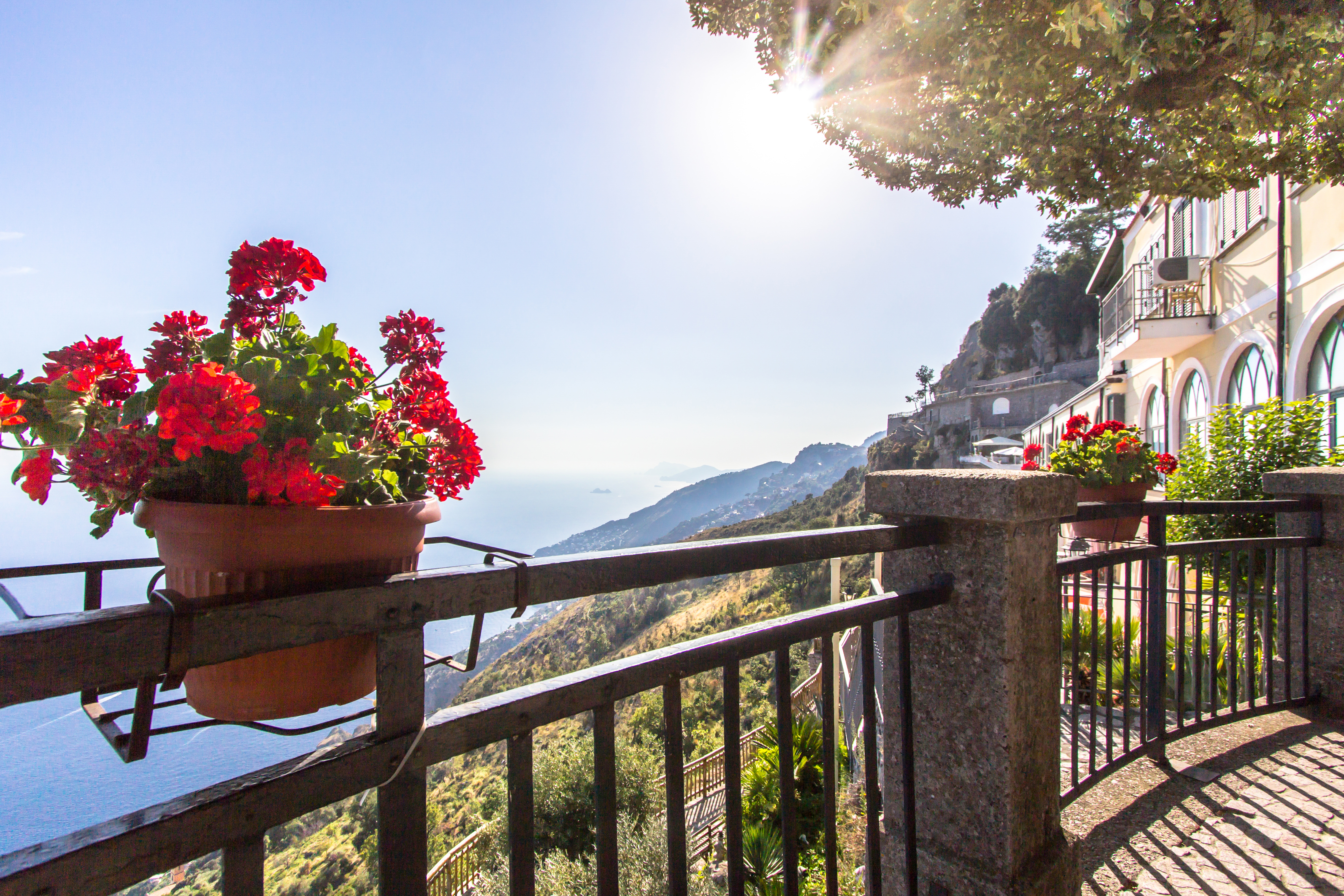 Smuk terrasse med røde geranier og udsigt over Amalfi-kysten og Middelhavet