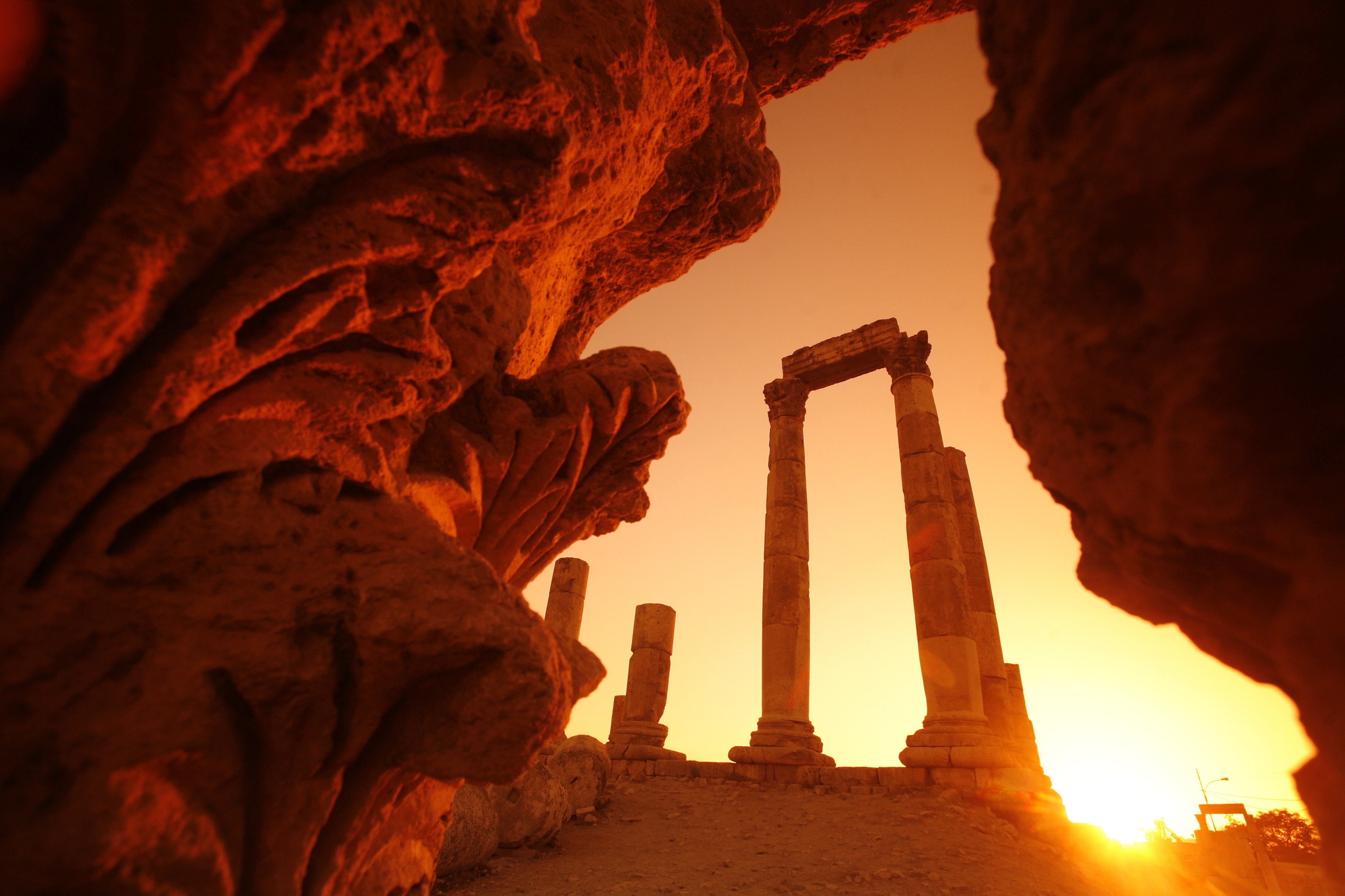 Antikke romerske tempelruiner ved solnedgang i Amman Citadel, Jordan med dramatisk orange belysning