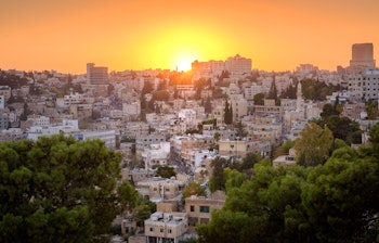 Romerske ruiner i Amman Citadel-parken ved solnedgang med panoramaudsigt over Jordans hovedstad og den historiske gamle bydel