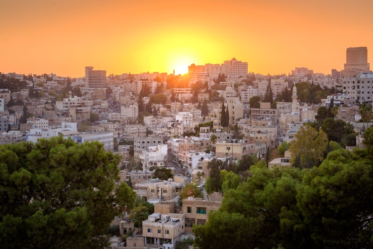 Romerske ruiner i Amman Citadel-parken ved solnedgang med panoramaudsigt over Jordans hovedstad og den historiske gamle bydel