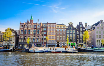 Traditionelle hollandske kanalhuse og både langs Amsterdams vandfront i Nederlandene