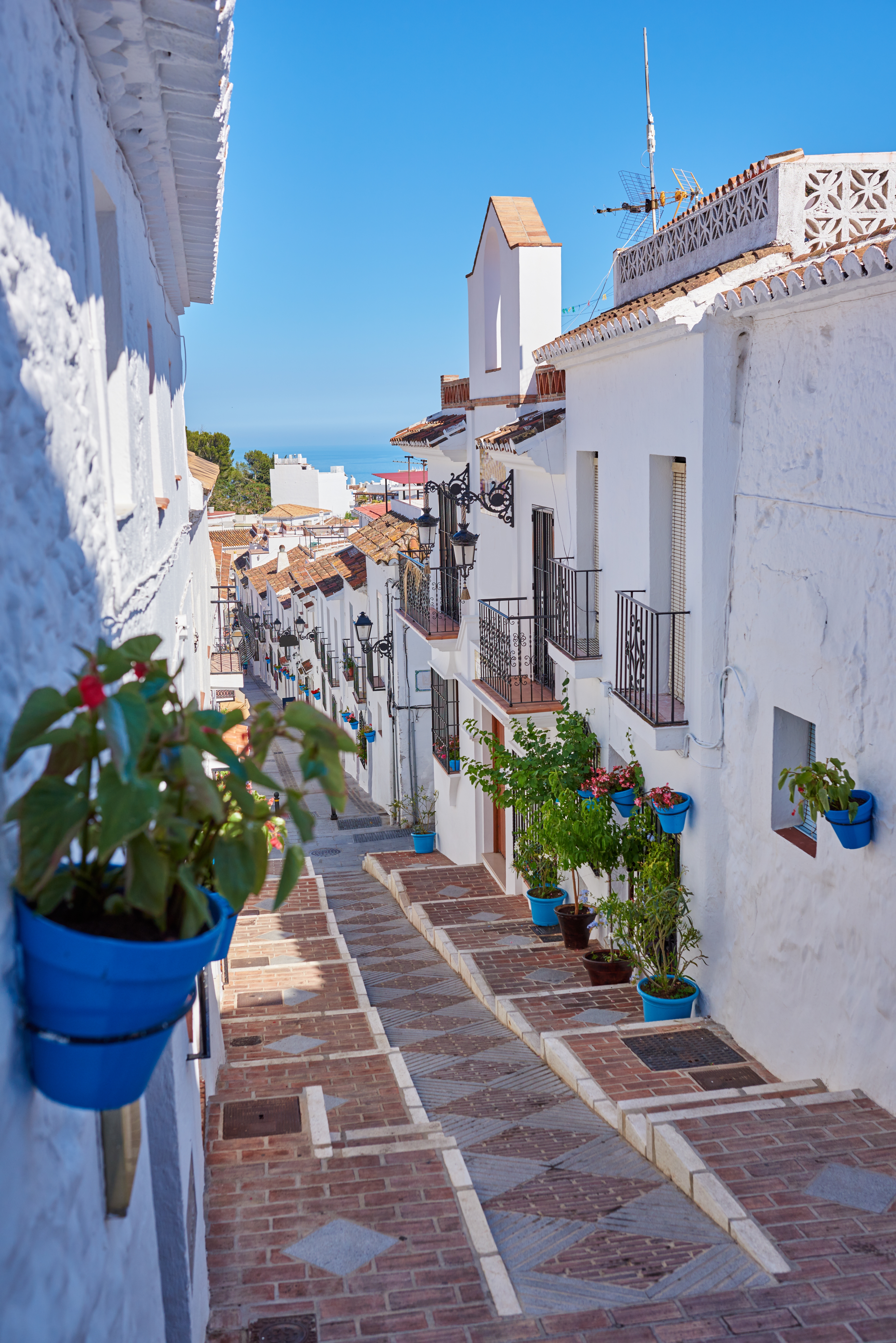 Traditionel andalusisk landsby med hvide huse, blå blomsterkrukker og charmerende gader i Spanien