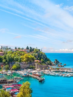 Luftfoto af Antalyas historiske Kaleici-kvarter med azurblåt Middelhav, lystbådehavn og farverige bygninger langs den tyrkiske kyst