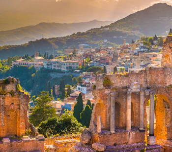 Det antikke teater i Taormina på Sicilien med udsigt over Middelhavet og Etna-vulkanen ved solnedgang