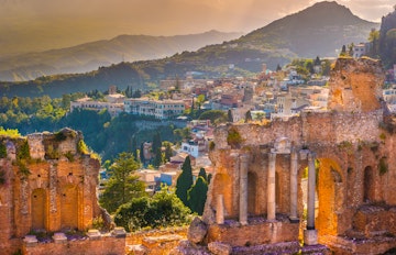 Det antikke teater i Taormina på Sicilien med udsigt over Middelhavet og Etna-vulkanen ved solnedgang