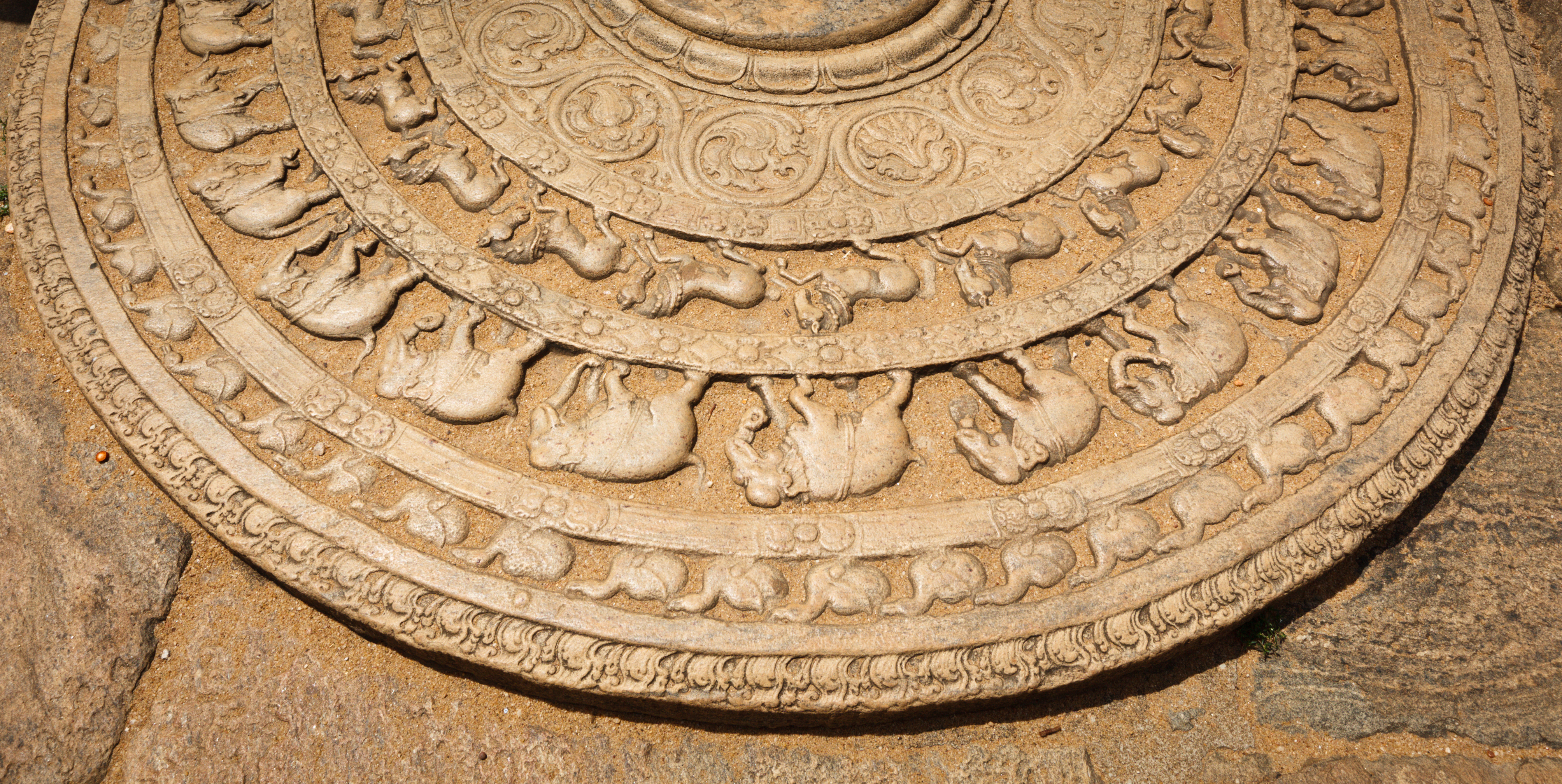 Historisk moonstone (sandakada pahana) med detaljerede udskaeringer ved indgangen til en buddhistisk dagoba i Anuradhapura, Sri Lanka - et imponerende eksempel paa tidlig singalesisk stenkunst