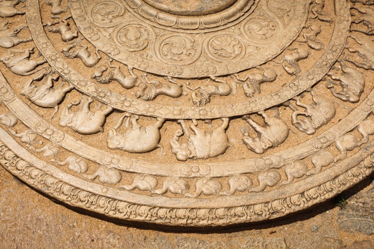 Historisk moonstone (sandakada pahana) med detaljerede udskaeringer ved indgangen til en buddhistisk dagoba i Anuradhapura, Sri Lanka - et imponerende eksempel paa tidlig singalesisk stenkunst