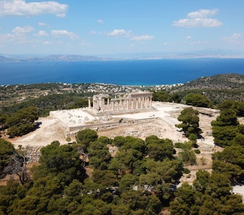 Betagende luftfoto af det antikke Aphaia-tempel med udsigt over Saroniske Bugt på øen Ægina, Grækenland