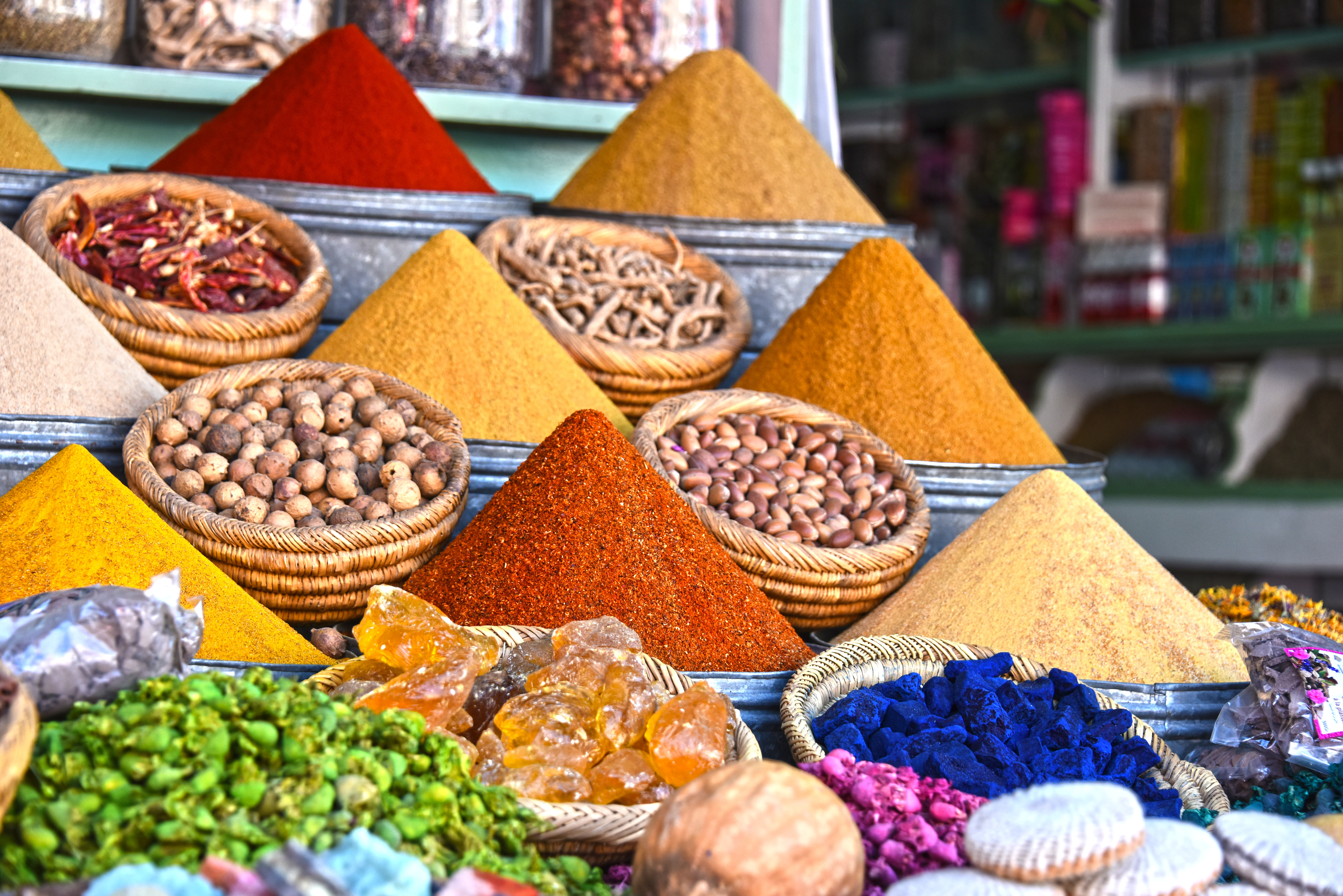 Farverige krydderier i kegleformede bunker på en traditionel arabisk markedsbod i Marrakech - eksotisk udvalg af gurkemeje, spidskommen, paprika og andre krydderier i en marokkansk souk