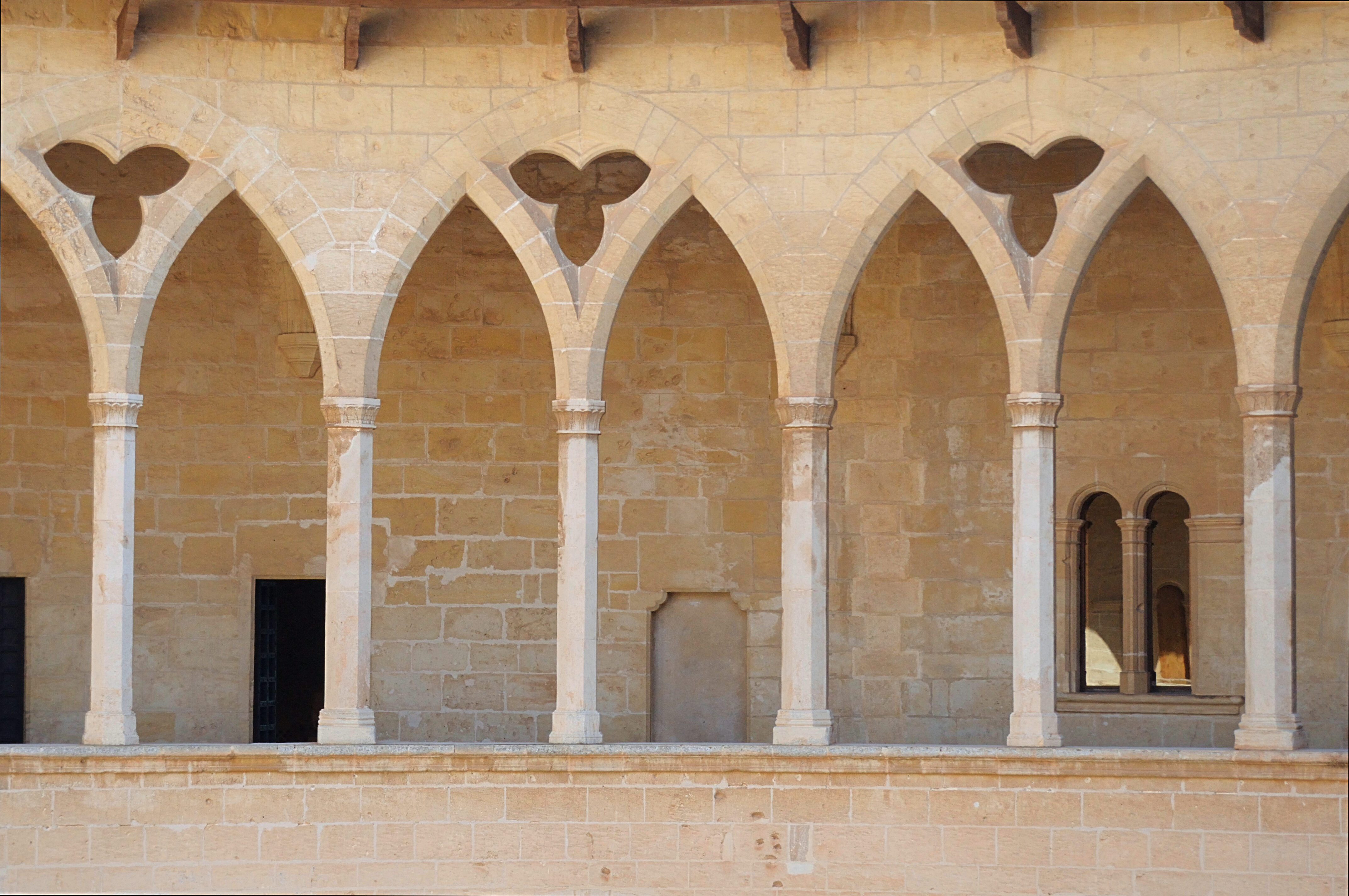 Arcaderne i Bellver Slot, en middelalderborg i Palma de Mallorca med historisk arkitektur.