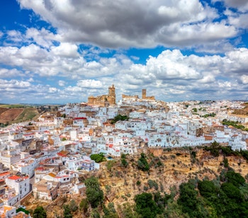 Betagende panoramaudsigt over Arcos de la Frontera, en historisk hvid landsby dramatisk placeret på en kalkstensklippe over Guadalete-floden i Cádiz-provinsen, Andalusien - oplev Spaniens smukke hvide landsbyer