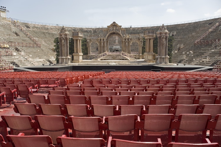 Indvendigt billede af Arena di Verona, det historiske romerske amfiteater i Italien med karakteristiske røde stensæder og sceneområde