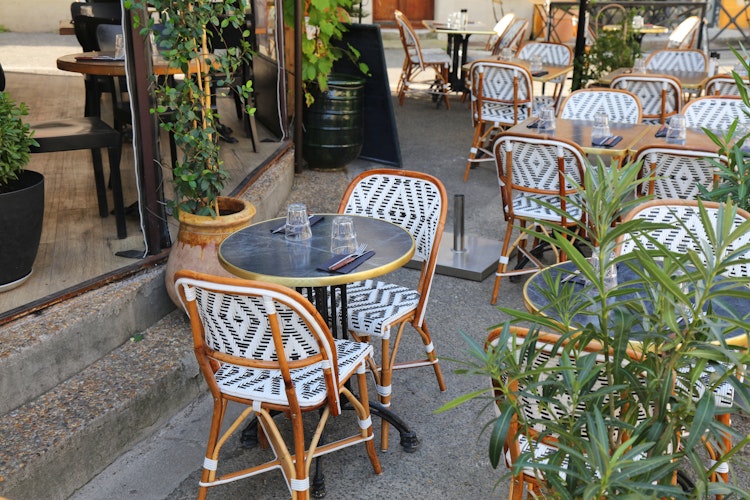 Charmerende gade cafe med kurvemøbler i historiske Arles, Provence, Frankrig