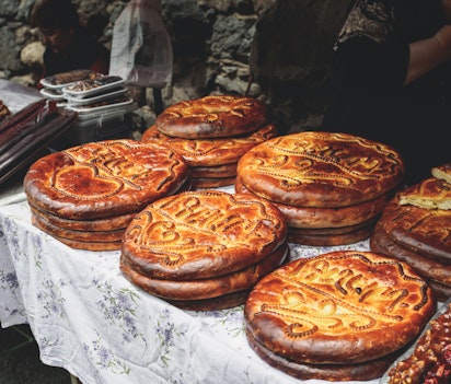 Kvinde holder traditionelt armensk gata-brød på en markedsbod, et gyldent sødt bagværk der er en vigtig del af Armeniens madkultur og kulinariske arv