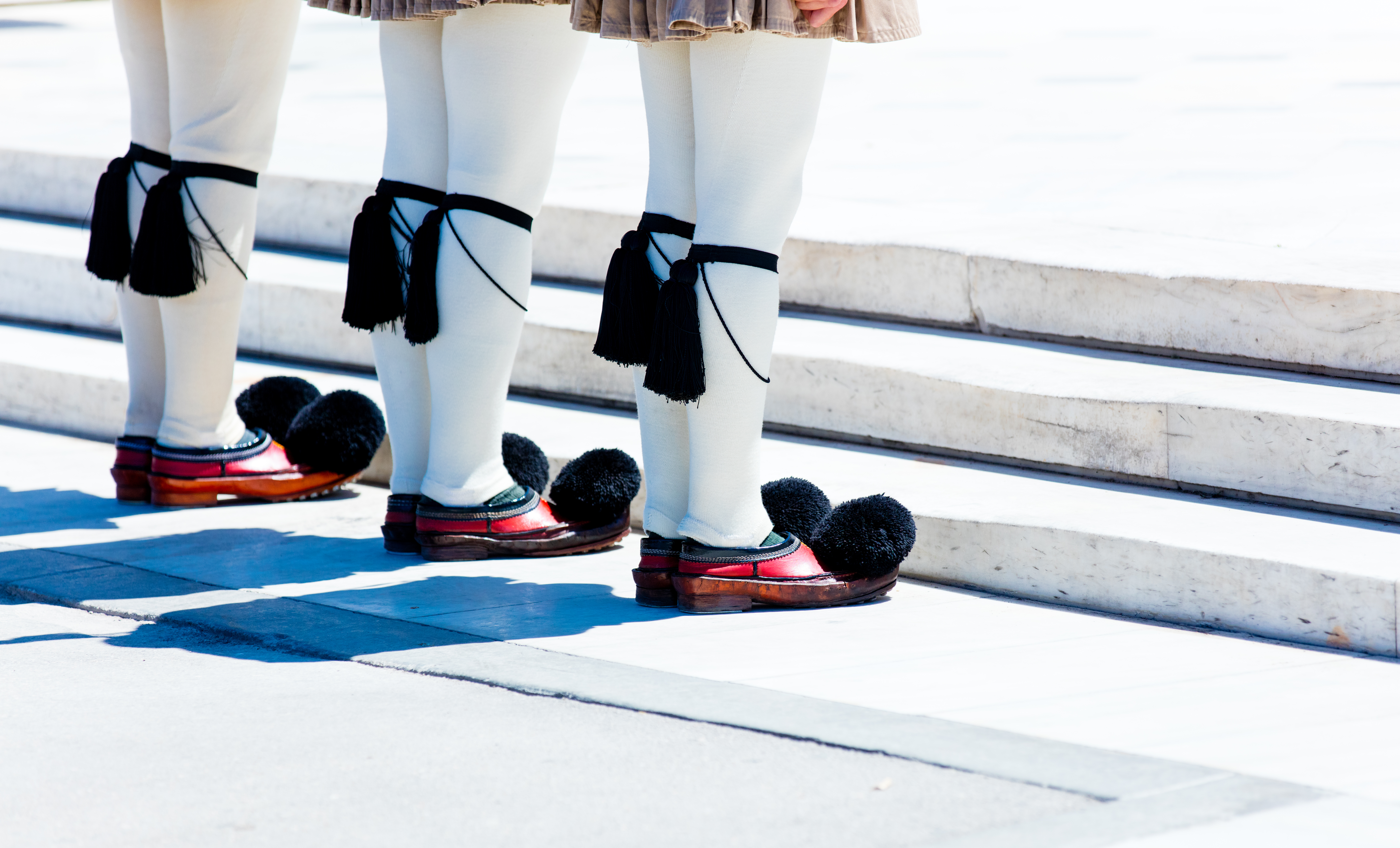 Ceremonielle Evzone-garder i traditionel græsk uniform med karakteristiske hvide strømper og røde sko med pomponer