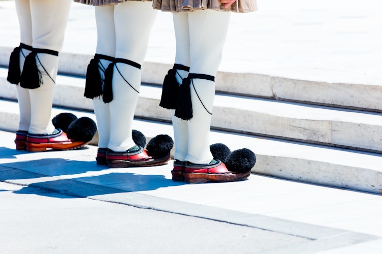 Ceremonielle Evzone-garder i traditionel græsk uniform med karakteristiske hvide strømper og røde sko med pomponer