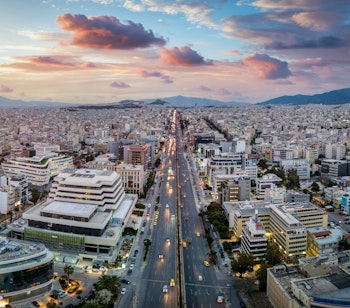 Luftfoto af Athens skyline ved solnedgang med Syggrou Avenue der forbinder de sydlige forstæder med Grækenlands historiske hovedstad