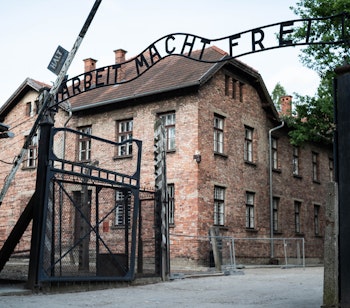 Hovedindgangen til koncentrationslejren Auschwitz-Birkenau med den berygtede inskription "Arbeit Macht Frei", nu et vigtigt historisk mindesmærke i Polen