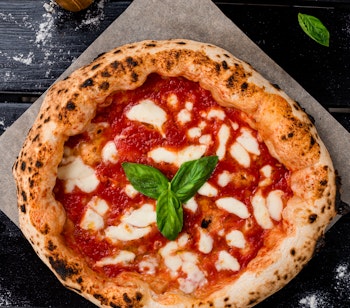 Traditionel napolitansk pizza margherita med frisk mozzarella og basilikum - en ægte smagsprøve på Syditaliens gastronomiske tradition