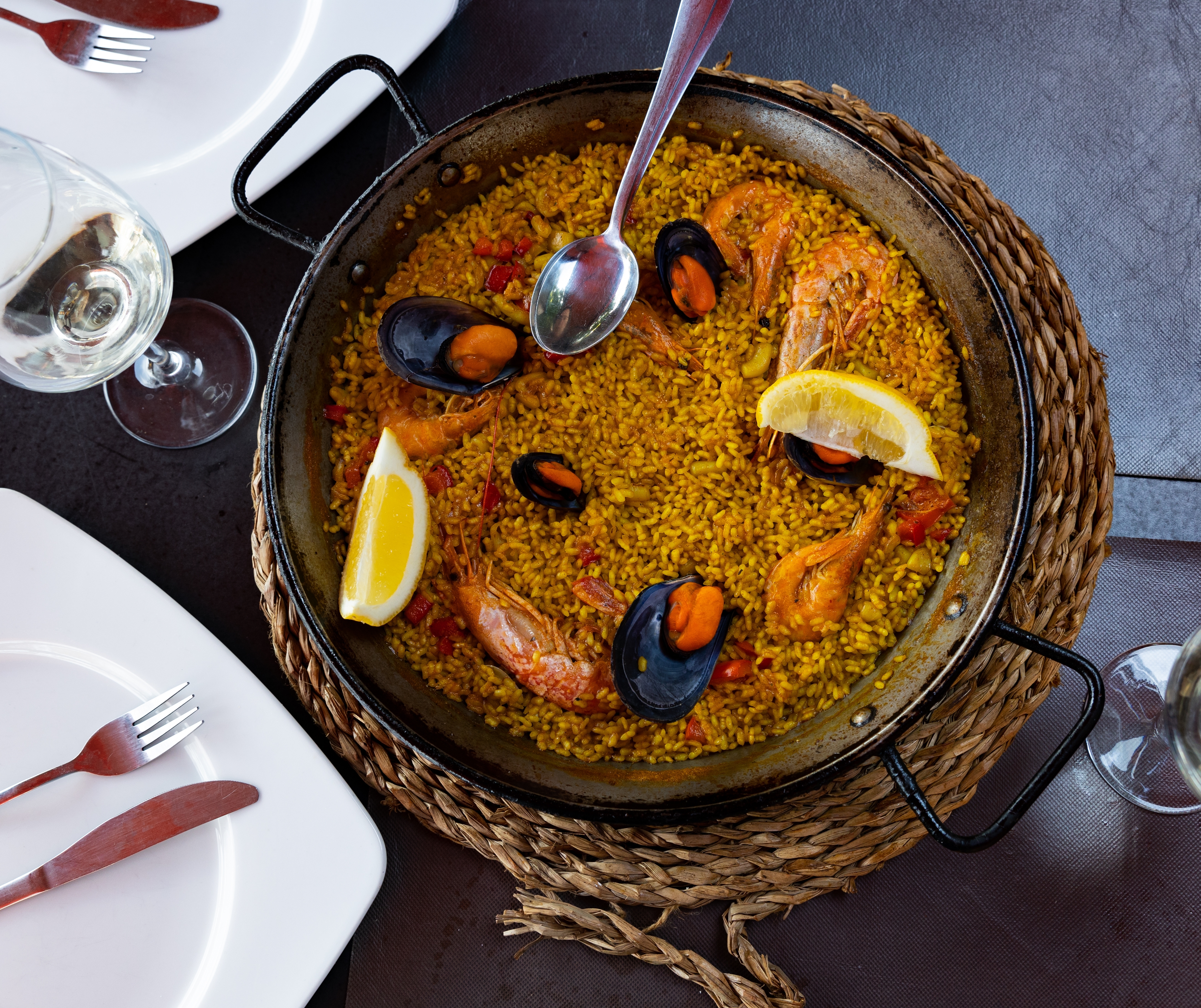 Traditionel valenciansk paella med friske skaldyr og citron serveret i original paellapande, en kulinarisk oplevelse på vores solformørkelsesrejse