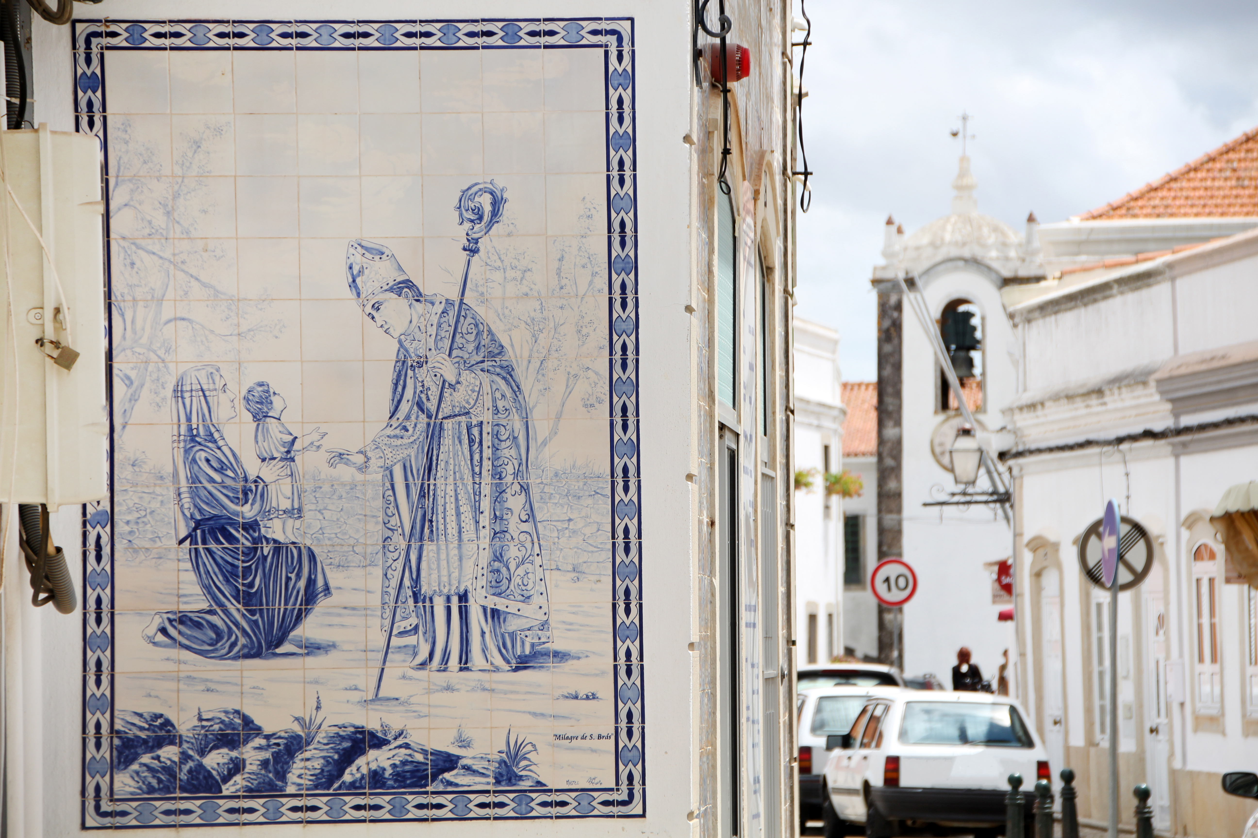 Detaljeret nærbillede af traditionelle portugisiske azulejo-fliser med religiøst kristent motiv fra São Brás de Alportel i Algarve, et vidnesbyrd om regionens rige kulturhistorie