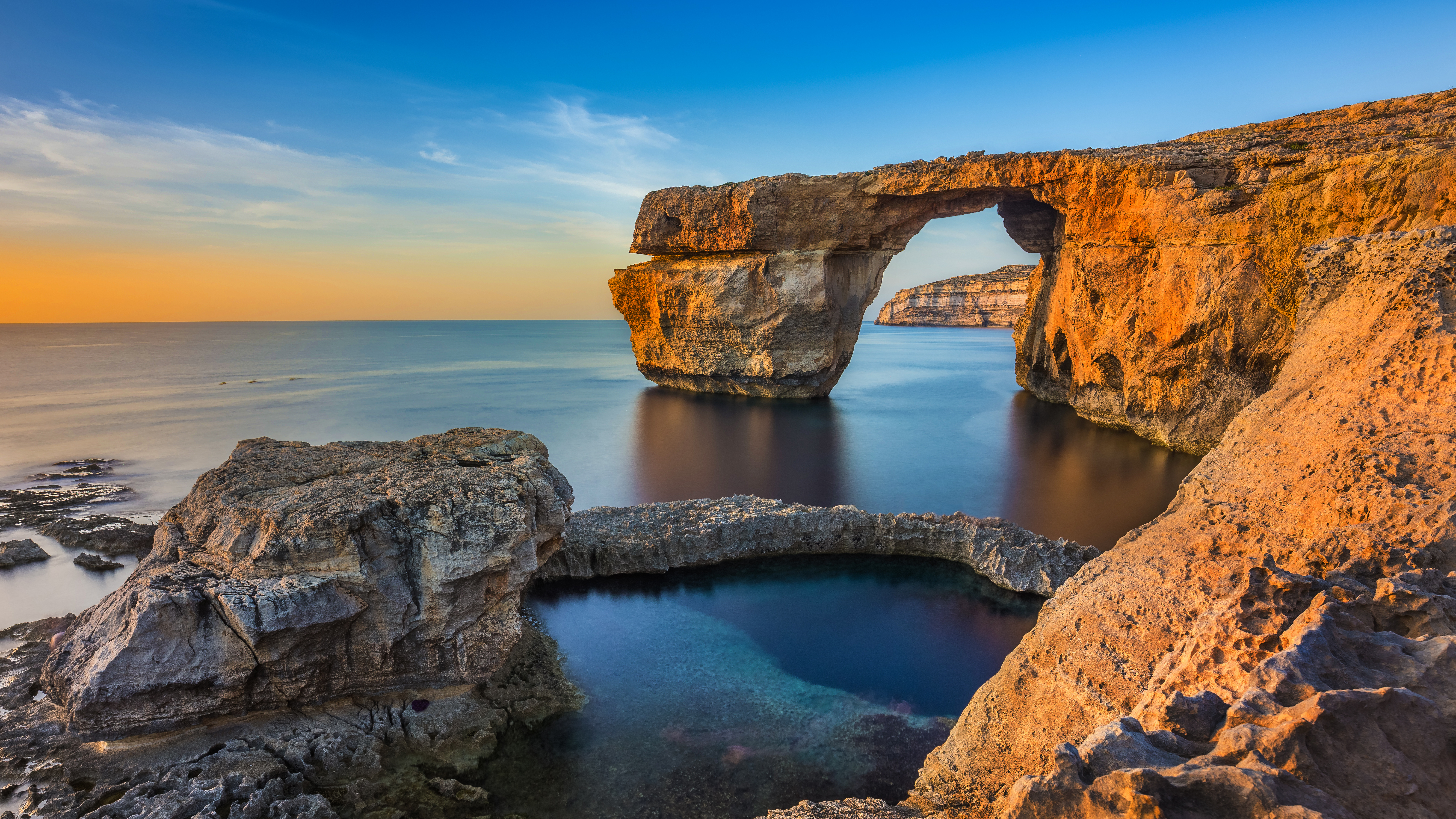 Den ikoniske Azure Window kalkstensformation på Gozo, Malta, badet i gyldent solnedgangslys over det blå Middelhav
