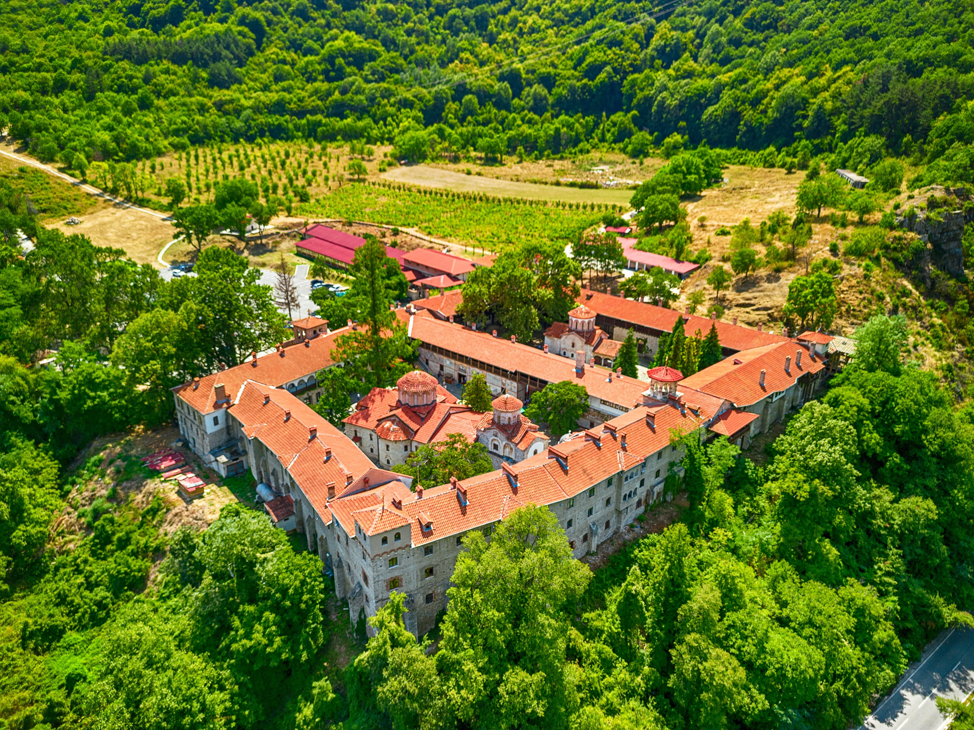 Luftfoto af det historiske Bachkovo Kloster omgivet af grønne skove i Rhodope-bjergene, Bulgarien