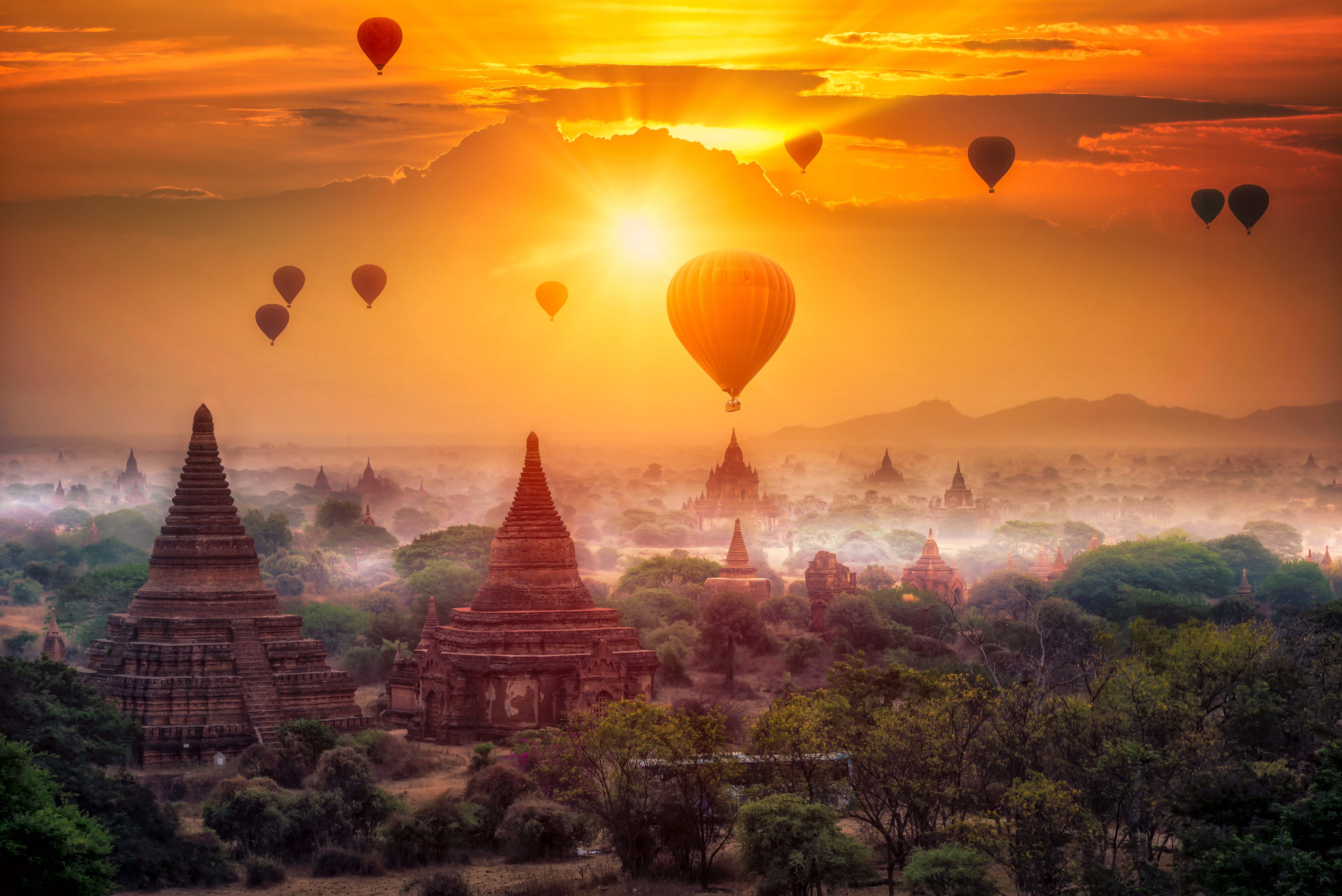 Varmluftsballoner over gamle buddhistiske templer i Bagan, Myanmar ved solopgang