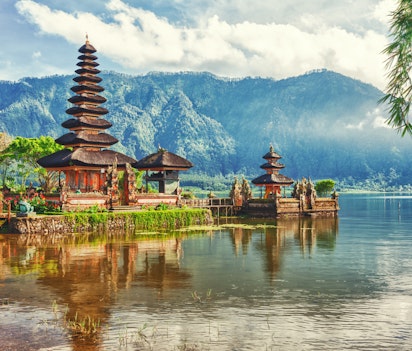 Det ikoniske Pura Ulun Danu tempel ved Beratan-søen på Bali med majestætiske bjerge i baggrunden