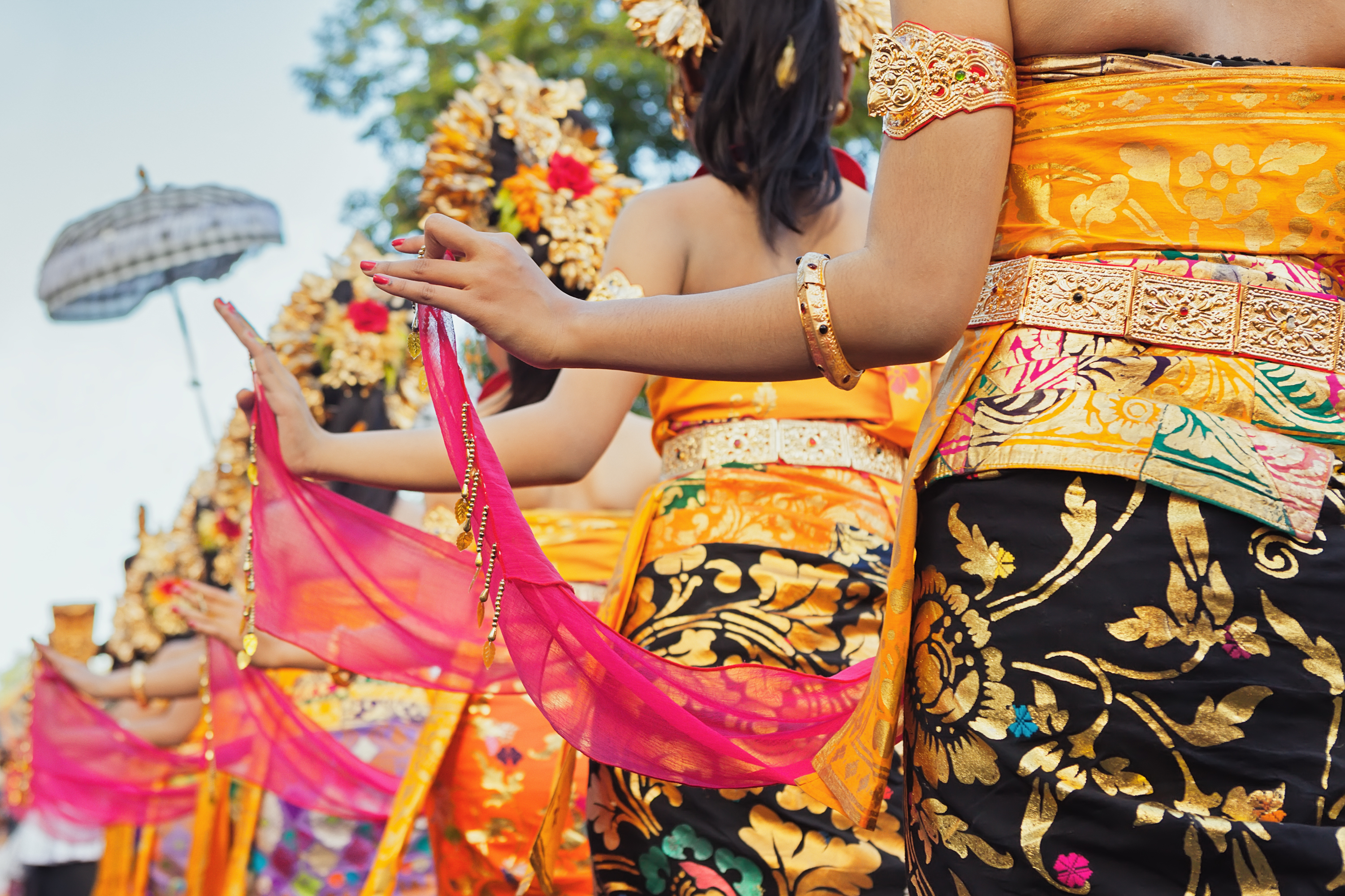Traditionelle balinesiske dansere i praegtige guldfarvede kostuumer udfører kulturel dans på Bali