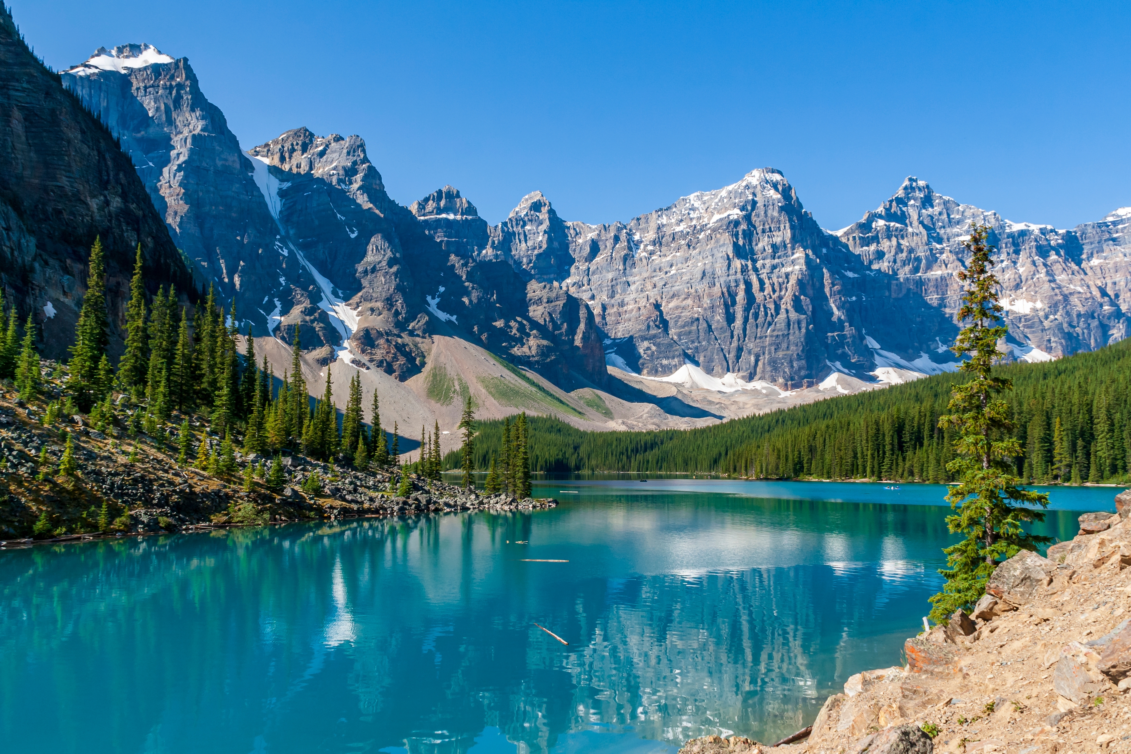 Smuk turkisblå sø med spejlblanke refleksioner af sneklædte bjerge i Banff Nationalpark Canada