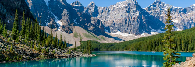 Smuk turkisblå sø med spejlblanke refleksioner af sneklædte bjerge i Banff Nationalpark Canada